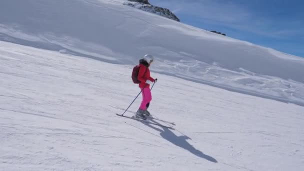 W ruchu, Kobieta narciarz na nartach w dół stoku góry na narty — Wideo stockowe