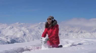 Mutlu kadın bir güneşli bir gün, ağır çekim, hd dağda kar oynuyor.