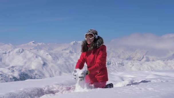 Ευτυχισμένη γυναίκα που παίζει στο χιόνι του βουνού για μια ηλιόλουστη μέρα, αργή κίνηση, hd. — Αρχείο Βίντεο