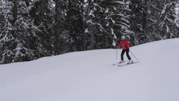 Новичок осторожно катается на лыжах по склону на горнолыжном курорте — стоковое видео