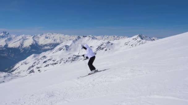 Žena lyže profesionálně dolů svahu v horách — Stock video