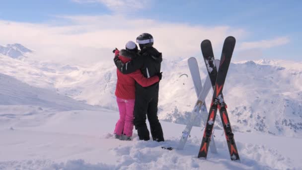 Verliebtes Paar steht auf dem Gipfel des schneebedeckten Berges und bewegt die Hände — Stockvideo