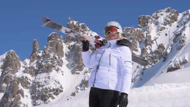 Mujer esquiadora con esquís en el hombro admira la belleza de la naturaleza en las montañas — Vídeos de Stock