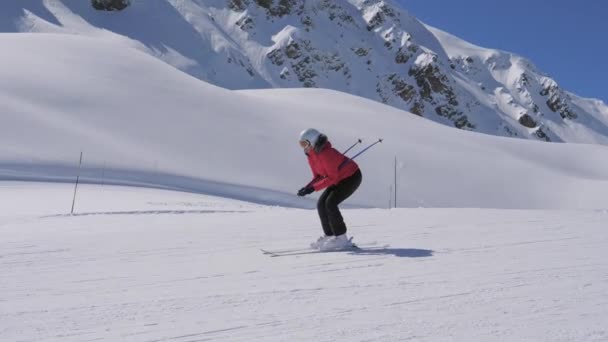 Vrouw skiër skiën van de berghelling ze zitten aan snelheid winnen — Stockvideo
