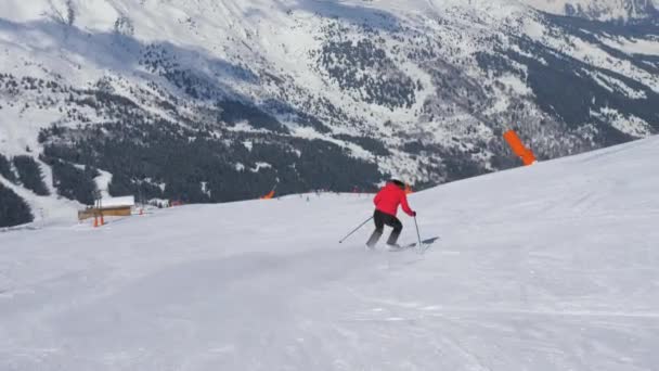 Starsza kobieta narciarz na nartach w dół stoku w górach w zimie i hamulce — Wideo stockowe