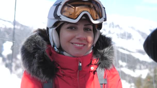 Zbliżenie, uśmiecha się kobieta narciarz wznosi się siedzi w wyciągu kolejki linowej — Wideo stockowe