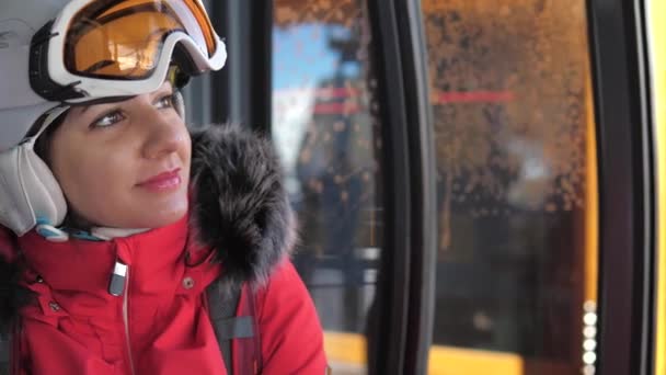 特写微笑的可爱的妇女滑雪者上升坐在滑雪缆车缆车 — 图库视频影像