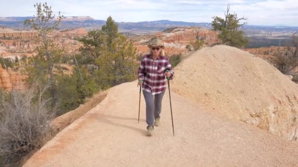 Ξανθιά ώριμη γυναίκα πεζοπόρος ανεβαίνει μονοπάτι της Bryce Canyon, Utah, ΗΠΑ — Αρχείο Βίντεο