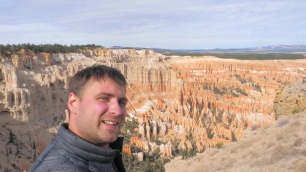 Un hombre tomando selfie en el Bryce Canyon Rocks fondo — Vídeos de Stock