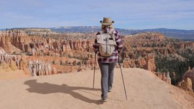 Uzun yürüyüşe çıkan kimse kadın kenarına gelir, Bryce Canyon ve döner etrafında ileri görünüyor