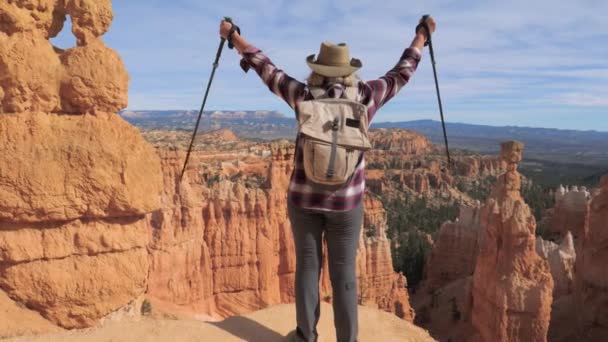 Μια γυναίκα πεζοπόρος θέτει τα χέρια της, στέκεται πάνω από την άκρη του Bryce Canyon — Αρχείο Βίντεο