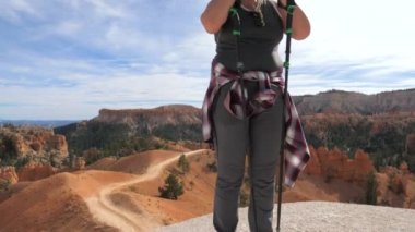 Bir kadın bir nefes alır ve saçlarını kısa bir mola Bryce Canyon giderir.