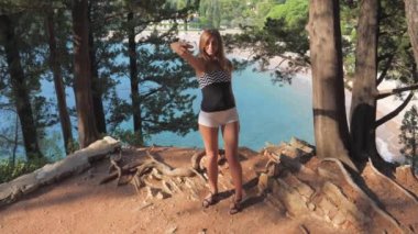 Kenar Rock arka plan deniz ve çam Selfies alarak güzel genç kadın