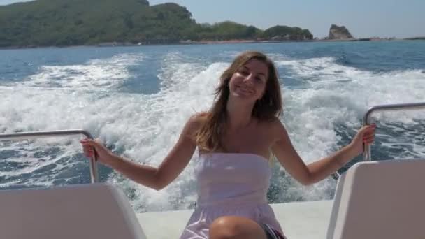 Una mujer bastante joven sentada en un barco flotante en el mar — Vídeo de stock