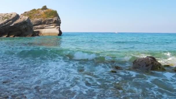 Волны на берегу лазурного моря с камнями — стоковое видео