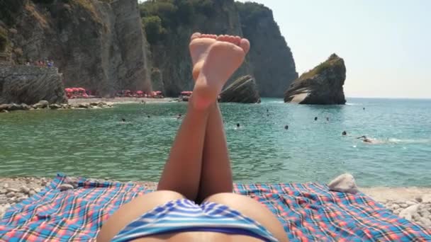 Budva, Montenegro-10 de septiembre de 2017: Mujer en bikini toma el sol a orillas del mar — Vídeos de Stock