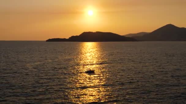 Pequeña lancha a motor navegando en el mar al atardecer de oro en el camino soleado — Vídeos de Stock