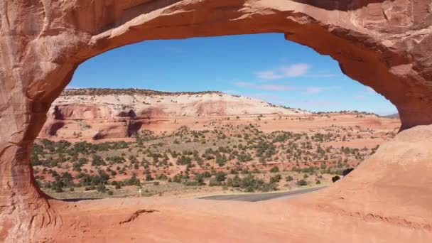 Drone flyger genom röd apelsin sten båge med massiva klippformationer i Utah — Stockvideo