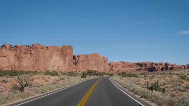 Jízda na prázdné silnici přes úžasné oblouky Národního parku v Utahu na slunečný den — Stock video