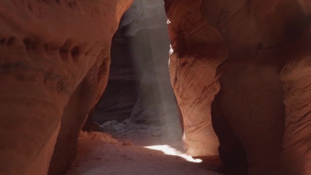 Paprsek slunečního světla svítí v temné jeskyni hluboký štěrbinový kaňon Buckskin Gulch — Stock video