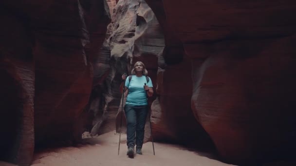 Turistvandring på torr flod i djupa Slot Canyon med orange stenar Bildning — Stockvideo