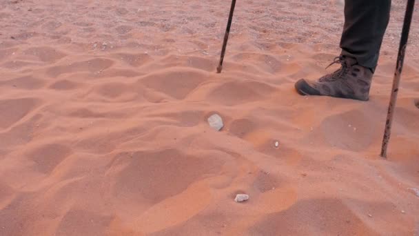 Ноги в сапогах Уставший путешественник пробирается через сухую песчаную пустыню — стоковое видео