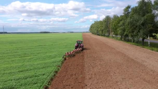 Tractor con flujos de flujo en la primavera del campo agrícola antes de plantar — Vídeos de Stock