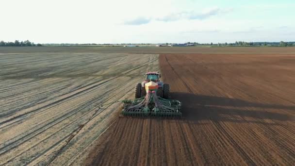 Trator com semeador semeia sementes de trigo em solo fertilizado de campo rural aéreo — Vídeo de Stock