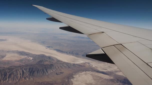 Ver asa e deserto com formações de rocha da janela de avião voando Altitude — Vídeo de Stock