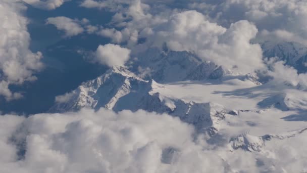 Vista desde aviones en alta montaña masivo en nieve y grandes glaciares en nubes — Vídeos de Stock