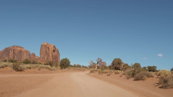 Похід на брудну дорогу в пустелі серед червоних кам "яних куточків долини монументів — стокове відео