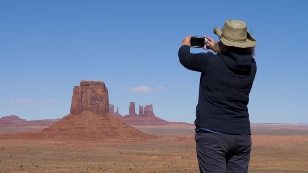 Frau an der Spitze des Aussichtstals Tal der Denkmäler macht ein Foto auf einem Smartphone — Stockvideo