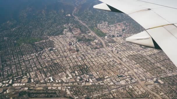 Θέα από αεροπλάνο που πετά πάνω από σπίτια κτίρια και αυτοκινητόδρομο της πόλης του Λος Άντζελες — Αρχείο Βίντεο