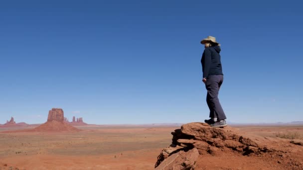 Tourist In Cowboy Hat Walking To Cliff Edge Of Viewpoint In Monument Valley Usa — Stock Video