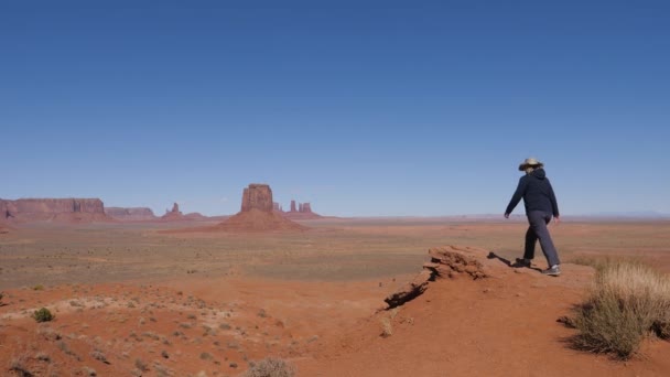 Kvinnan går till toppen och höjer armarna upp firar segern i Monument Valley — Stockvideo