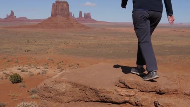 Turista en la cima y levanta sus brazos celebrando la victoria en Monument Valley USA — Vídeo de stock