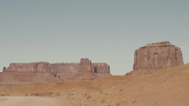 Вождение по пыльной грязной дороге в пустыне среди красных камней Buttes of Monument Valley — стоковое видео