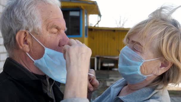 Donna anziana messo su suo marito maschera medica per proteggere il virus e la malattia — Video Stock