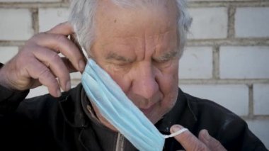 Virüsü ve hastalığı korumak için tıbbi maske takan yaşlı beyaz adamın portresi.