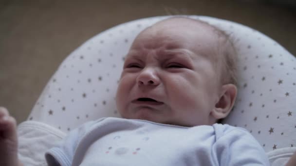 Fermer Portrait Nouveau-né en costume de corps pleure et agit — Video