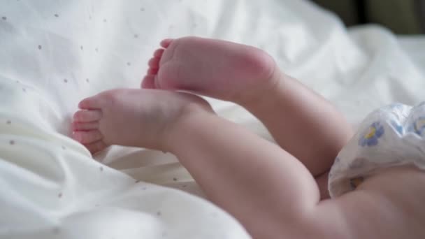 Close-up van een pasgeboren baby tangen kleine voeten met vingers in de wieg — Stockvideo