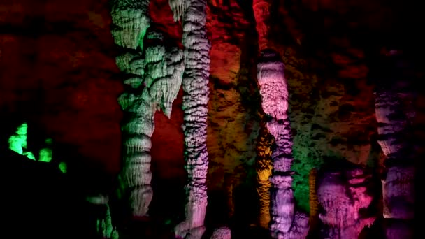 Cave With Stalactites And Stalagmites In Multicolored Illumination — Stock Video