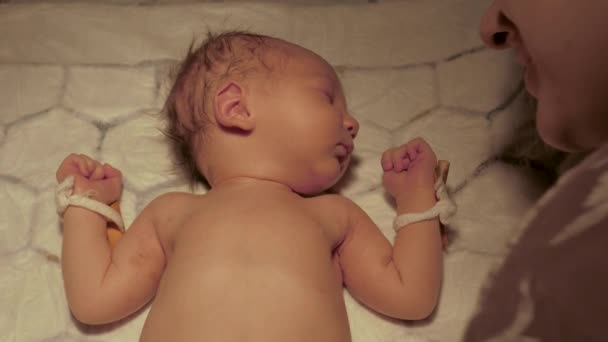 Mother Kiss Her Newborn Baby Is Lying Under Warm Lamp On Changing Table — Stock Video