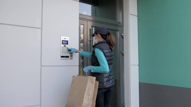 Corriere in maschera che indossa i guanti esegue la consegna di cibo durante il virus pandemico — Video Stock