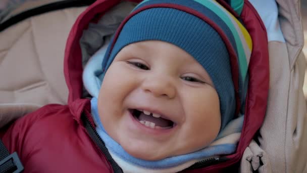 Porträtt av rolig leende liten bebis i varma kläder på promenad — Stockvideo