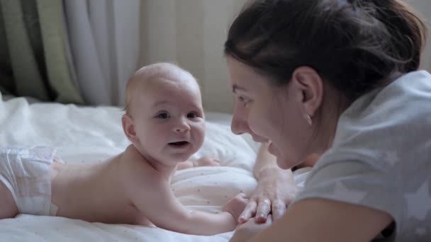 Anne ve yeni doğmuş bebeği birbirlerinin karşısındaki bir yatakta karın üstü yatıyorlar. — Stok video