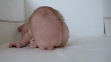 Bebek bezli yeni doğmuş bebek midesinde dönmeyi öğreniyor.