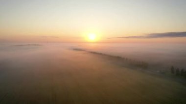 Sis bulutlarının arasından gün batımını karşılamak için hava uçuşu