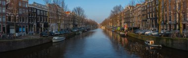 Amsterdam kanalı Panoraması. Tipik Hollanda evleri, köprü ve ev tekneleri. Holland, Hollanda. Amsterdam 'ın sakin kanallarında yansıtılan güzel Hollandalı bebek evleri.