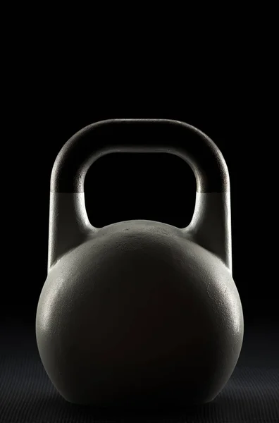 Silueta de peso de kettlebell de competición blanca retroiluminada en un piso de gimnasio — Foto de Stock